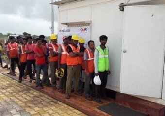Photograph of contractor workmen waiting in a que for eye check up